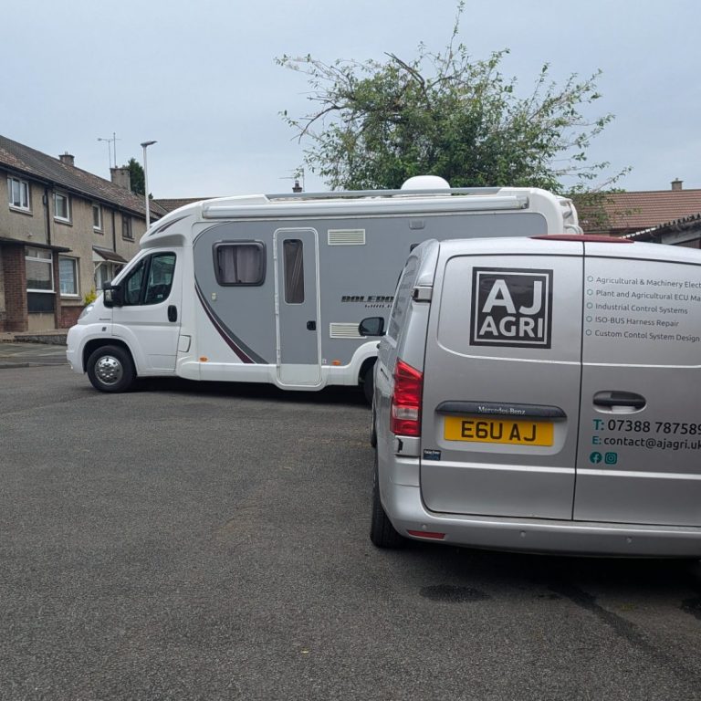 Rear view of AJ AGRI mobile auto electrical van with back doors open on-site, fixing a campervan non-start fault.