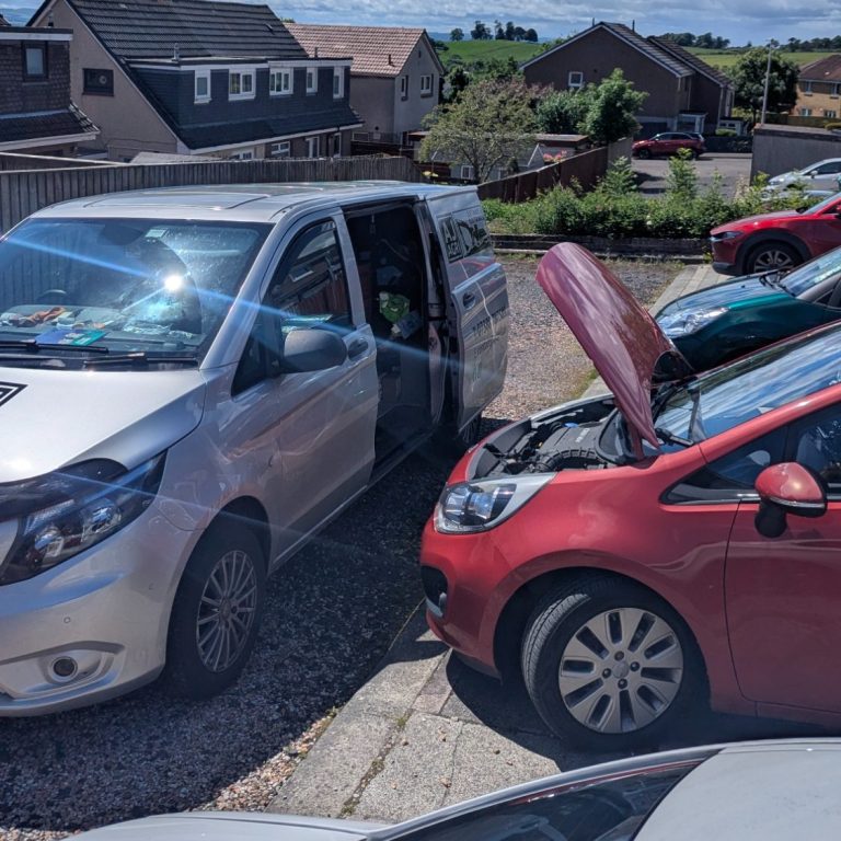 AJ AGRI van on-site diagnosing an engine management light (EML) fault on a Kia Rio with its bonnet up.